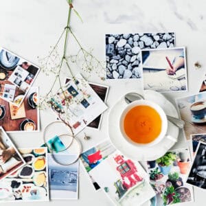 Fotos de recuerdos y momentos especiales en la mesa con té y fotografías variadas en estilo vintage.